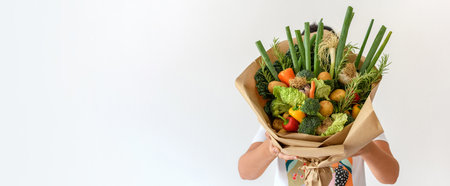 Close-up photo of woman holding fresh vegetables decorated into a bouquet.の写真素材