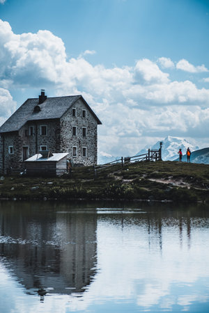 A vertical shot of a house near a lake under the cloudy skiesの写真素材