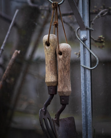 A vertical shot of gardening tools hanging from a cableの写真素材
