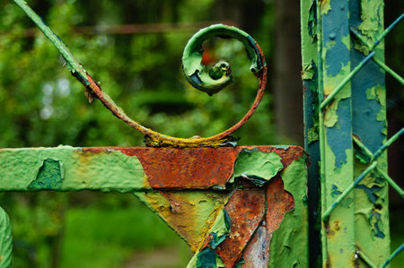 Detail of an old, rusty garden gate. Repeatedly painted over, the paint will peel off and the rust will prevail. Colourful structure.の写真素材