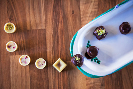 A top view of some black and white chocolate candies on a wooden backgroundの写真素材