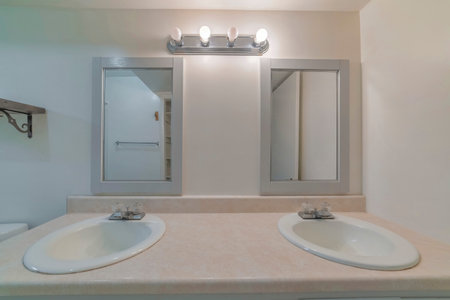 An image of two sinks, square mirrors with grey frames.
