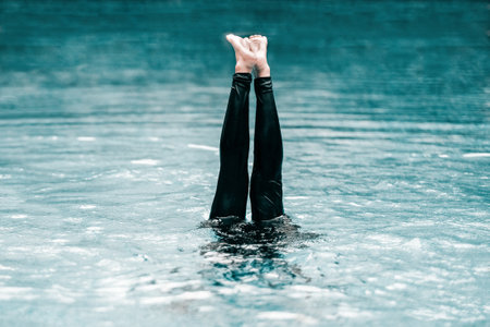 A shot of a person underwater with their lower body looking up out of it