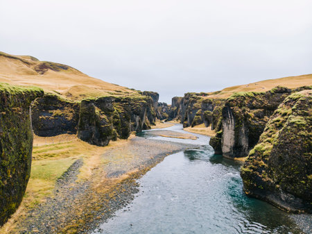 A beautiful view of a canyon with rocks covered in moss on a cloudy day
