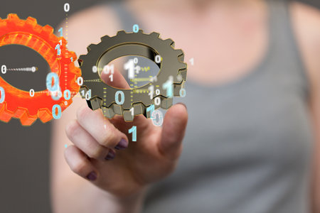An abstract shot of a woman's hand touching 3D rendered engineering gears in a virtual screenの写真素材