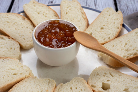 A closeup shot of a breakfast board with bread slices and a bowl of jam