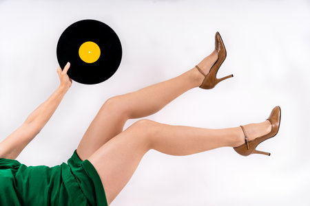 A sexy Caucasian woman keeps a vinyl on a white backgroundの写真素材