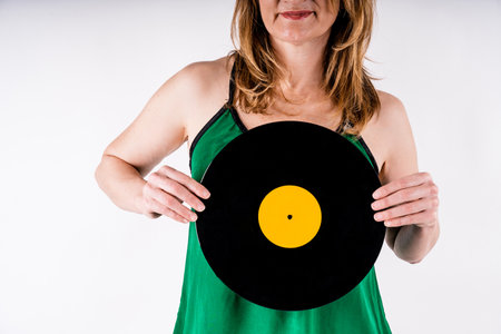 A sexy Caucasian woman keeps a vinyl on a white backgroundの写真素材
