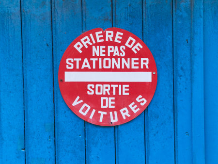 A red sign forbidding the parking in the area on a blue wooden surfaceの写真素材