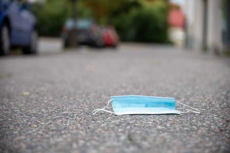 A closeup shot of a facial mask as trash in a streetの写真素材