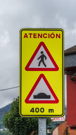 A closeup of yellow caution sign on the road on a gloomy dayの写真素材