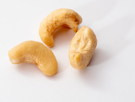 A close-up shot of cashew nuts on a white surface.の写真素材