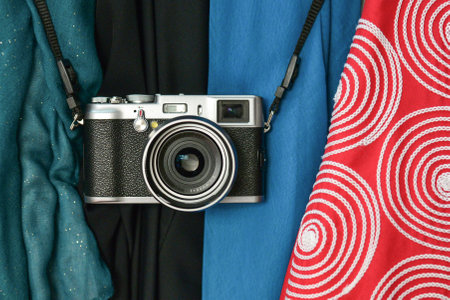 A closeup shot of a camera on colorful blankets with different designsの写真素材