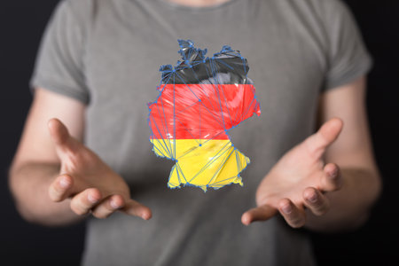 A 3d abstract of the map of Germany floating near handsの写真素材