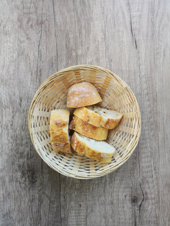 A vertical closeup of traditional organic bread in the bamboo basket. Top view.