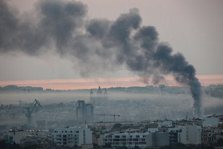 Smog from factories and vehicular traffic occupying lower lying areas of southern Malta, with black sooty smoke from burning rubber.の写真素材