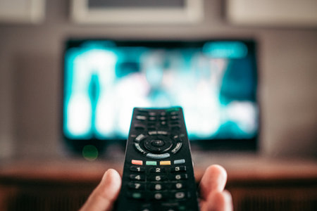 A closeup shot of a remote controller for a modern TV in a handの写真素材