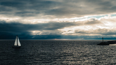 A sailing ship on the sea under a stormy sky in the daytimeの写真素材