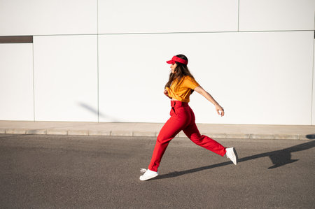 A stylish Caucasian female in a bright outfit posing outsideの写真素材