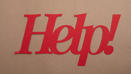 A red Help! sign on a brown backgrouCustomer support service hotline helpdeskの写真素材