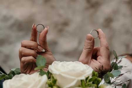 Selective focus of newlyweds holding wedding rings.の写真素材