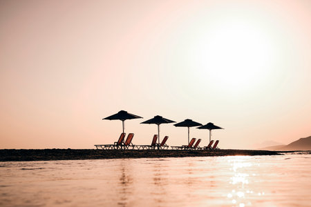 A shot of beach beads under canopies at the beach during sunsetの写真素材