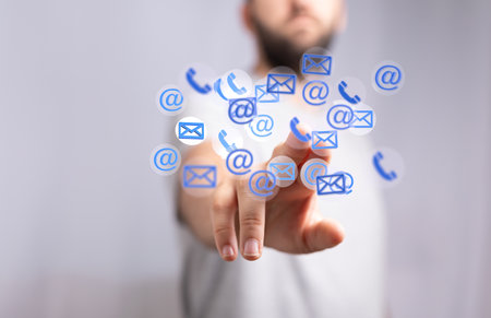 A human hand showing network communications with email and phone symbolsの写真素材