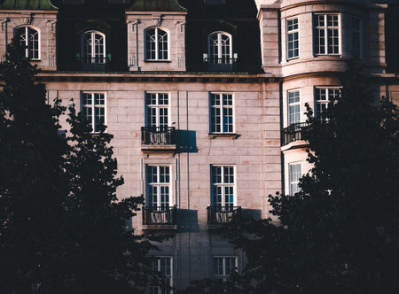 A closeup shot of the windows and the exterior design of a beautiful building in front of a big...
