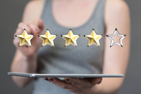 A 3D rendering of a four-star rating hovering over a tabletの写真素材