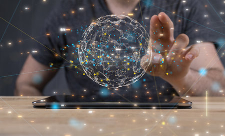 A 3D rendering of digital globe over a tablet with hand touching it from behind-Digital Network and...