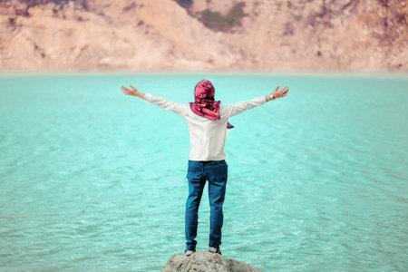A person standing on a rock and enjoying the ocean viewの写真素材