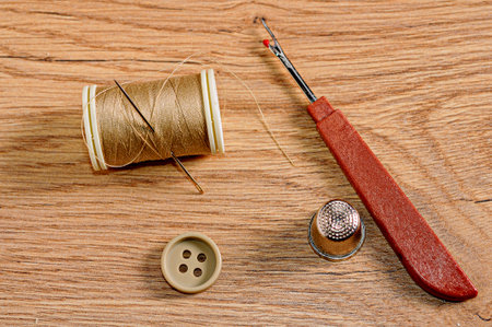 A top view of a button and rope roll, sewing tools on the wooden table