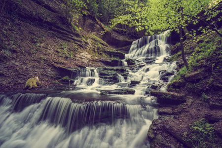 A mesmerizing view of the waterfall flowing over the rocksの写真素材