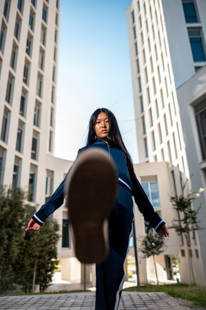 An attractive Asian woman in sportswear posing in the street