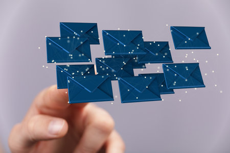 A 3D rendering of a businessman pointing at floating email icons against a gray backgroundの写真素材