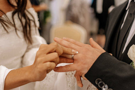 Bride and groom putting wedding rings on their hands during wedding ceremonの写真素材