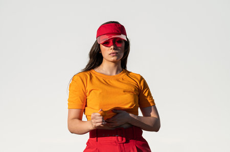 A stylish Caucasian female in a bright outfit posing outsideの写真素材