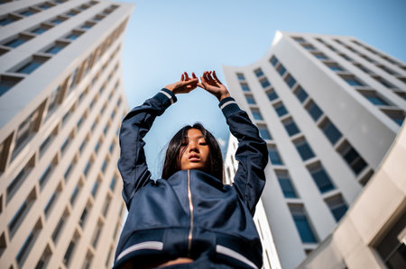 An attractive Asian woman in sportswear posing near the white building