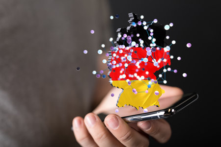 A 3D rendering of digital Germany map floating on human hand with phone- internet and global connection conceptの写真素材