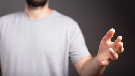 A male hand pushing on a touch screen on a black backgroundの写真素材