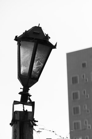 A close up shot of an old electrical light device in a public place, in black and whiteの写真素材