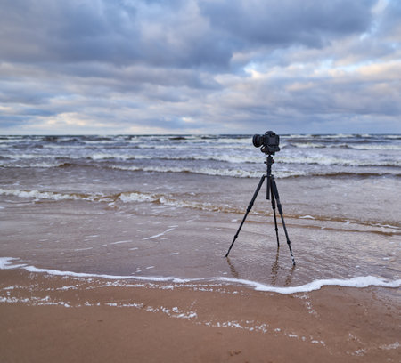 Camera on tripod on the beach. Cloudy weatherの写真素材