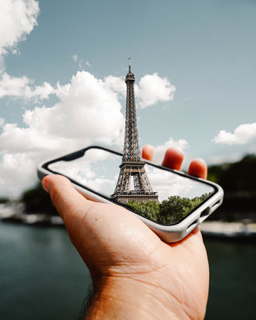 An edited montage of the Eiffel Tower emerging from a mobile phone.の写真素材