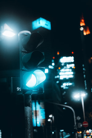 An urban view of blue neon pedestrian passing traffic light on the road at night
