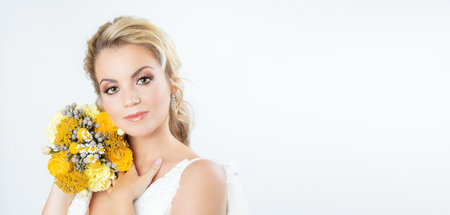 A vertical shot of a beautiful Caucasian bride in an elegant wedding dress posing on white backgroundの写真素材