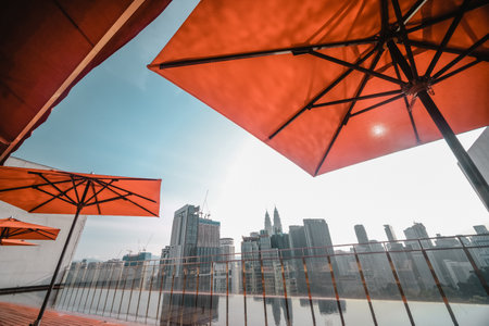 Several colorful umbrellas on the balcony with skyscrapers in the background