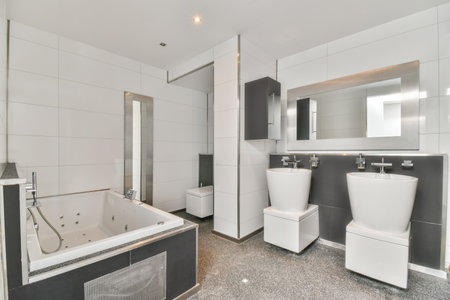 An interior shot of a bathroom with double sinks and white tiles on the walls