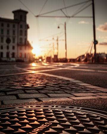 A selective focus of steel manhole cover on a street at sunsetの写真素材