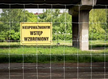 A sign on the fence grid with the text nieupowaznionym