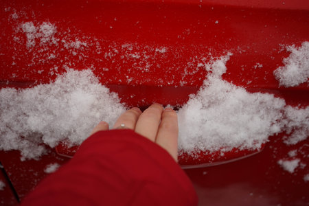 Woman's hand tries to open the side door of the car. the car is full of snow.の写真素材